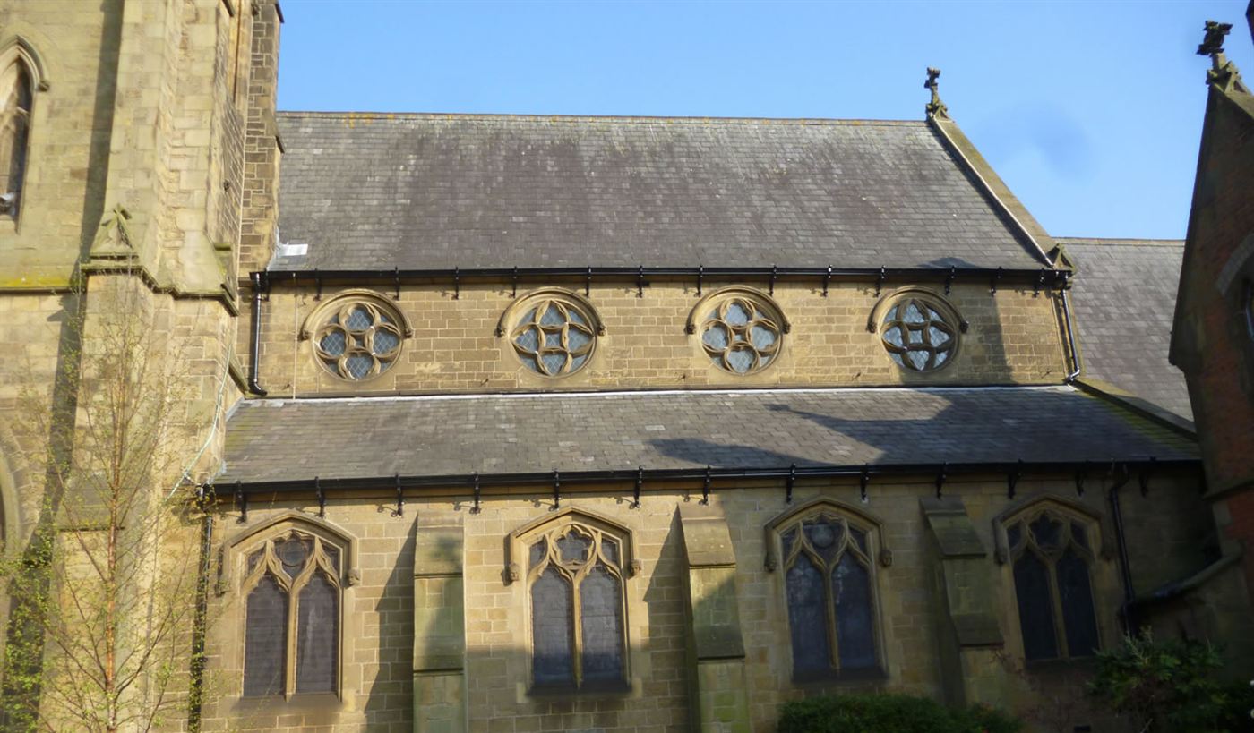 Cast-iron guttering restored across two roof levels of a gothic sandstone church in Wrexham